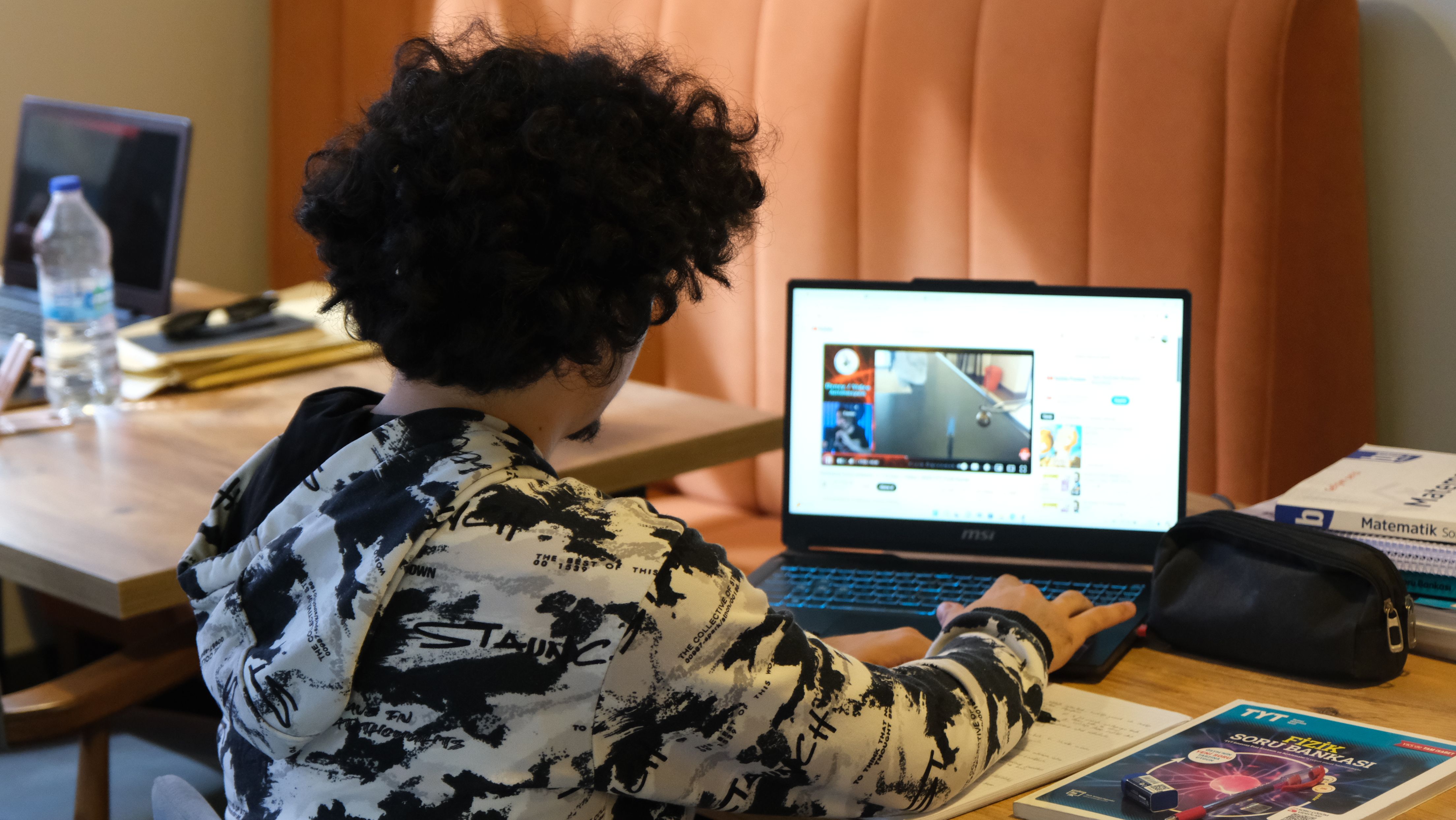 Teenager using a laptop for schoolwork at home, illustrating student use of AI tools