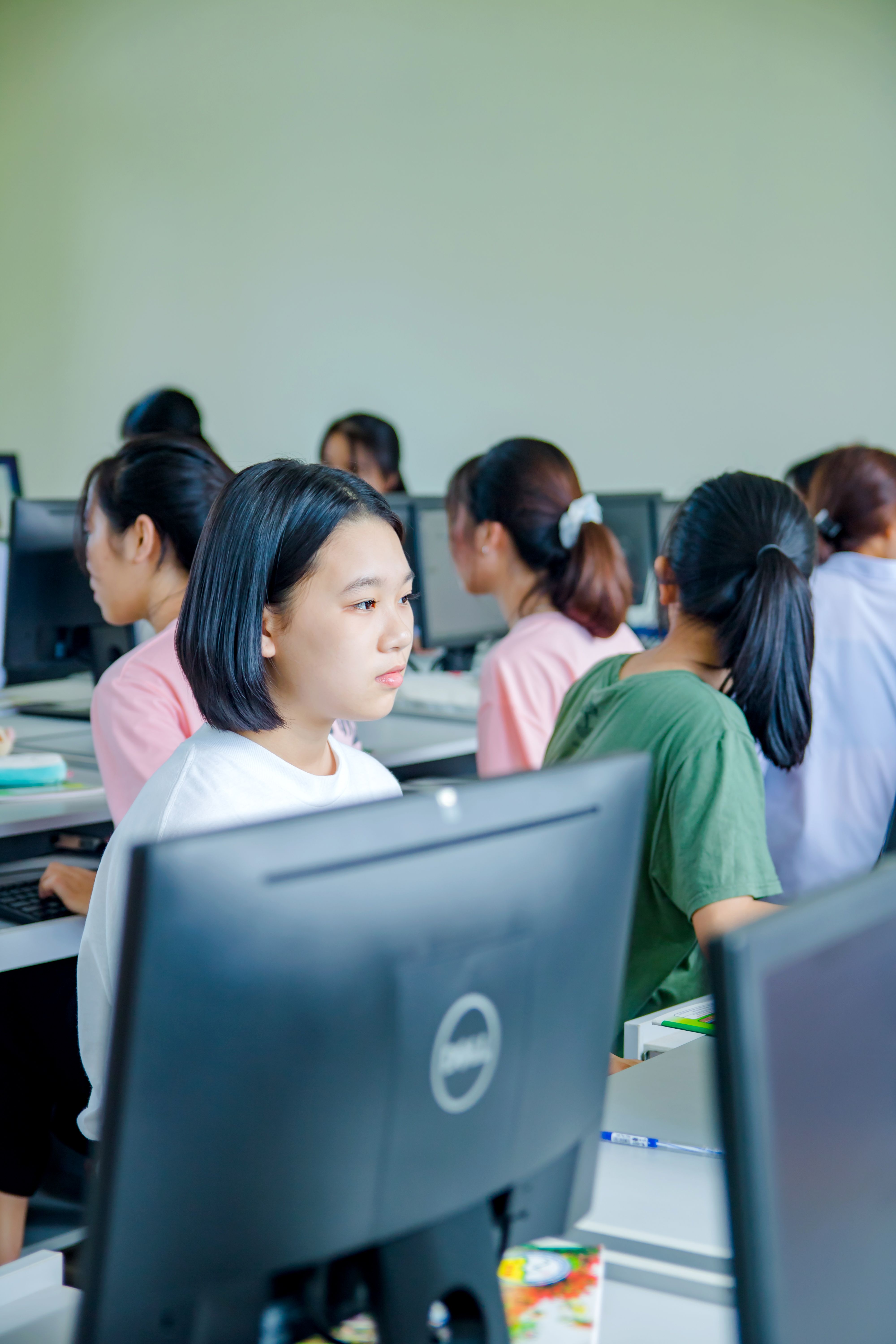 Students working on computers in a classroom lab, evoking academic integrity concerns
